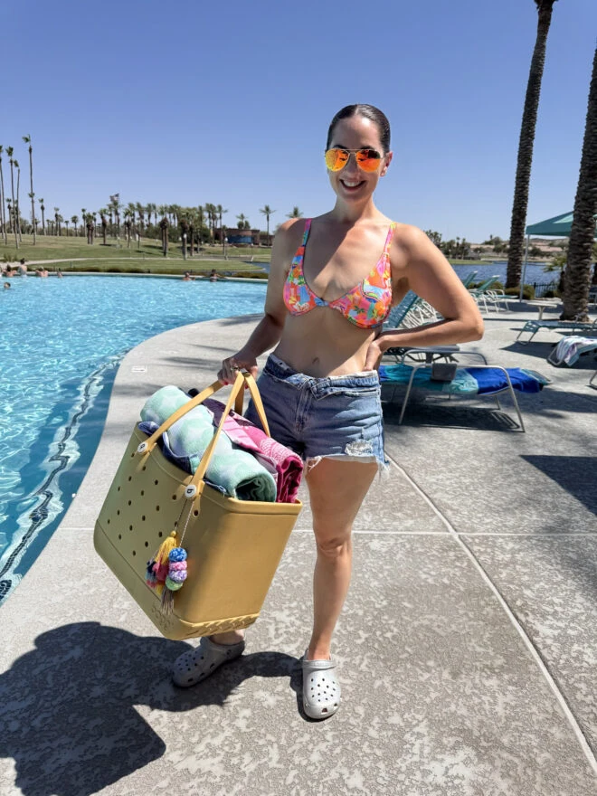 Natasha at the pool holding a large pool bag full of summer essentials