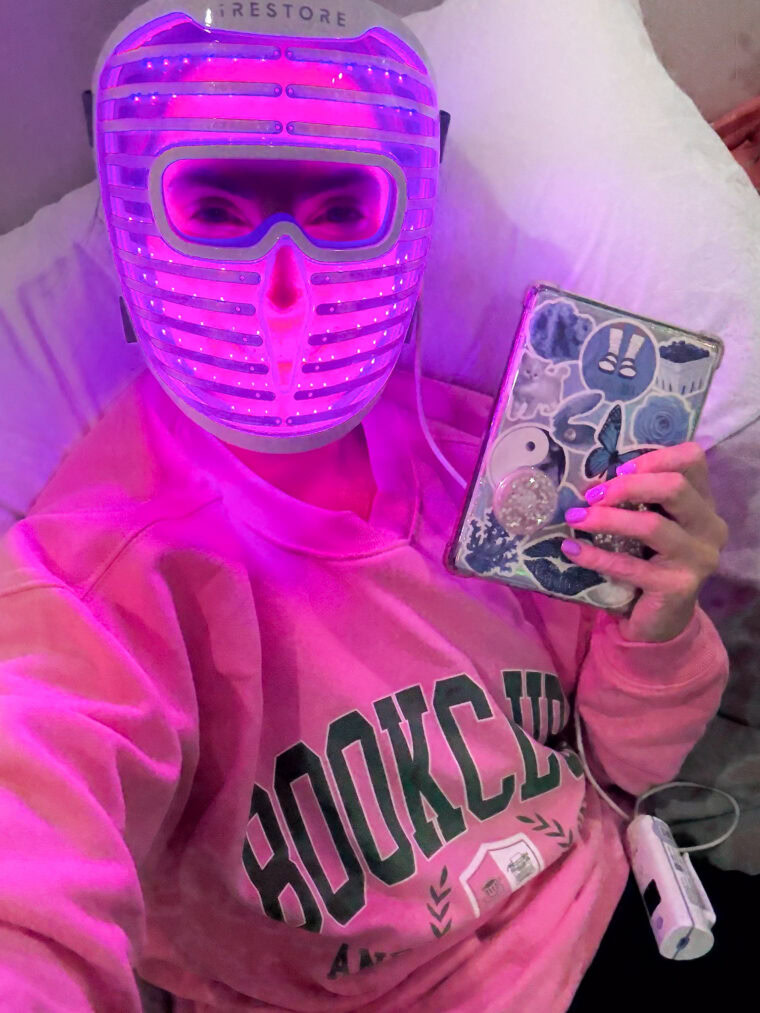 Reading on a Kindle while wearing a red light therapy mask before bed
